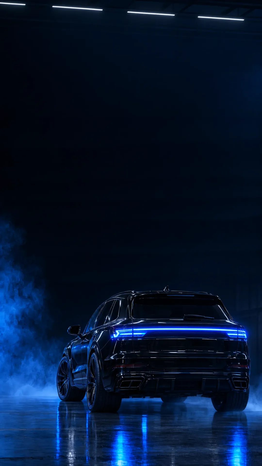 A black SUV under blue light in a dark studio