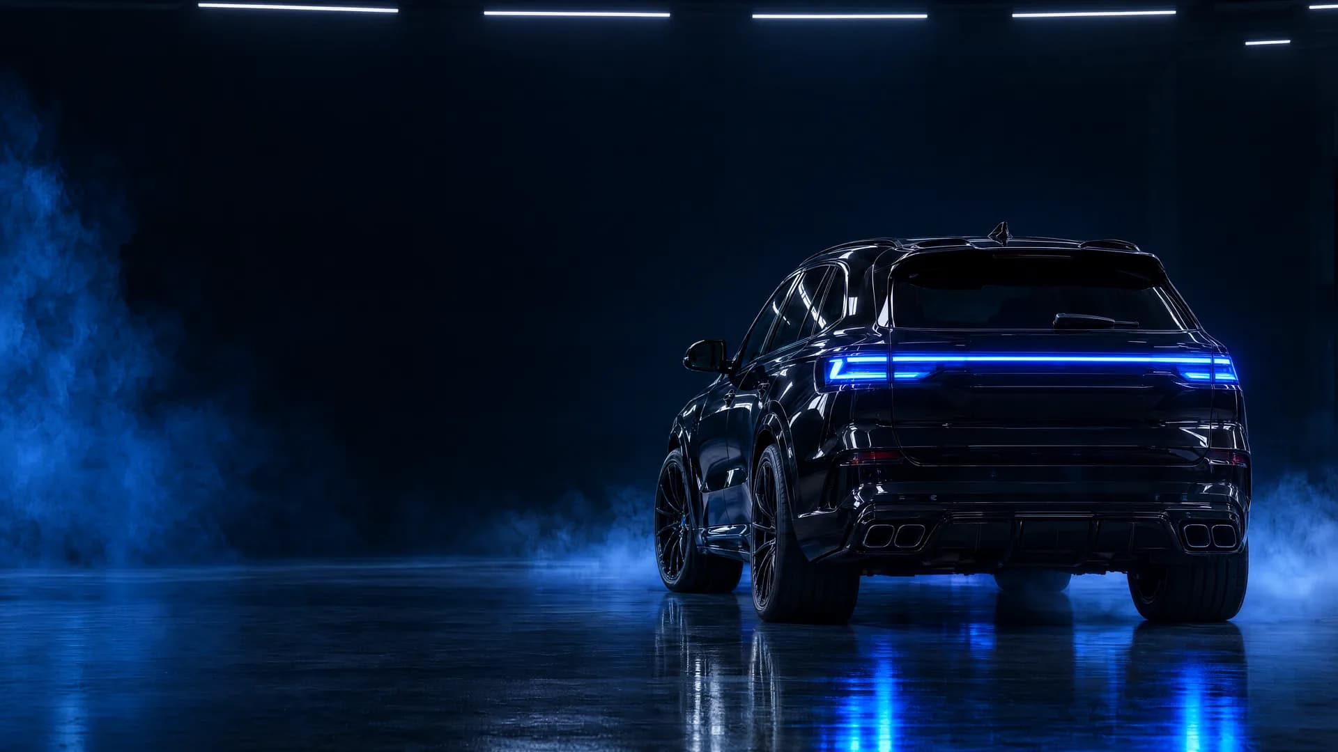 A black SUV under blue light in a dark studio